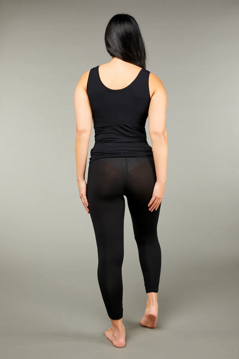 Woman wearing a black scoop neck tank top with black full length leggings back view on grey background