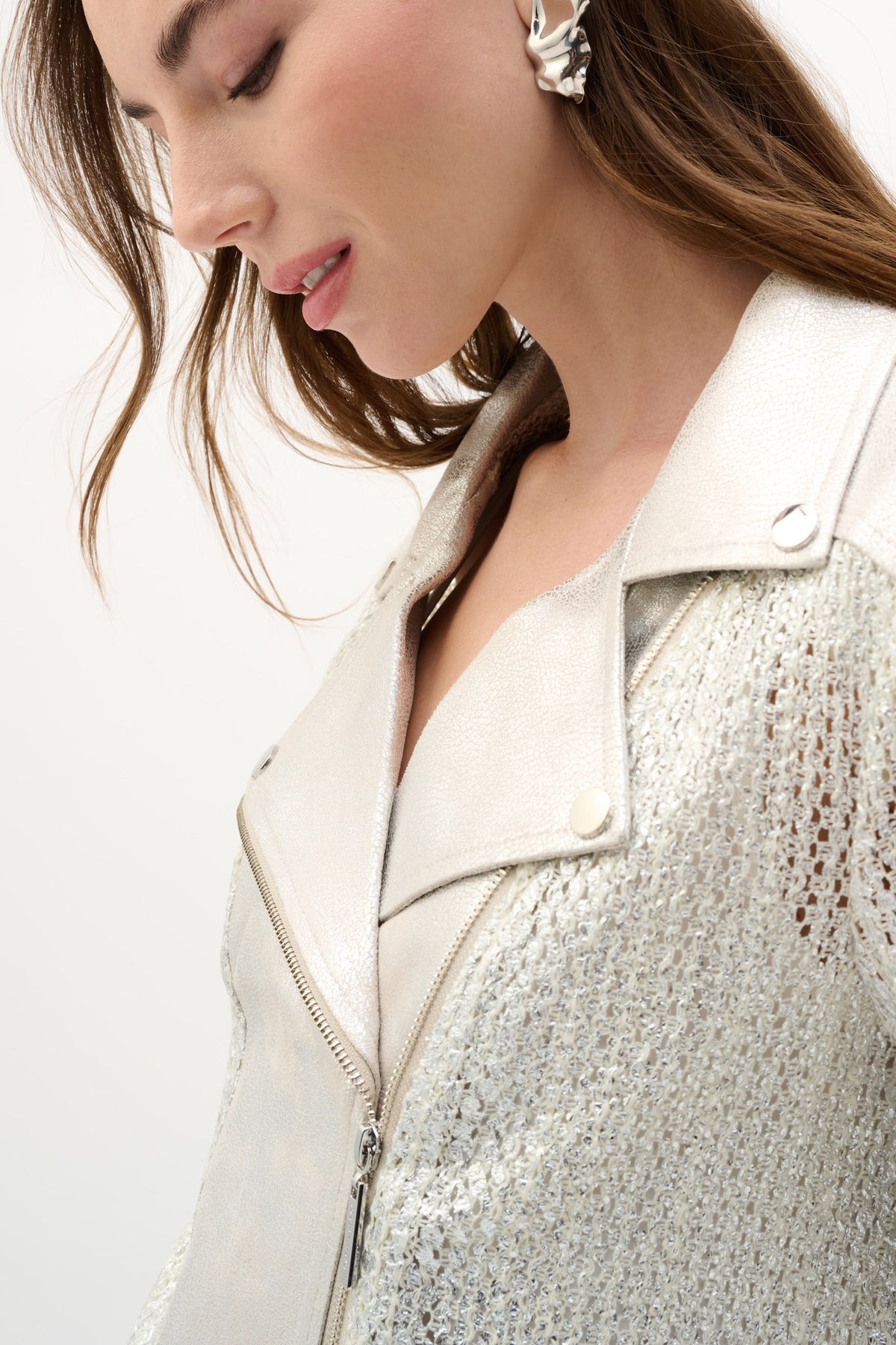 Close-up view of silver textured metallic jacket showing detailed fabric finish and structured lapel design.