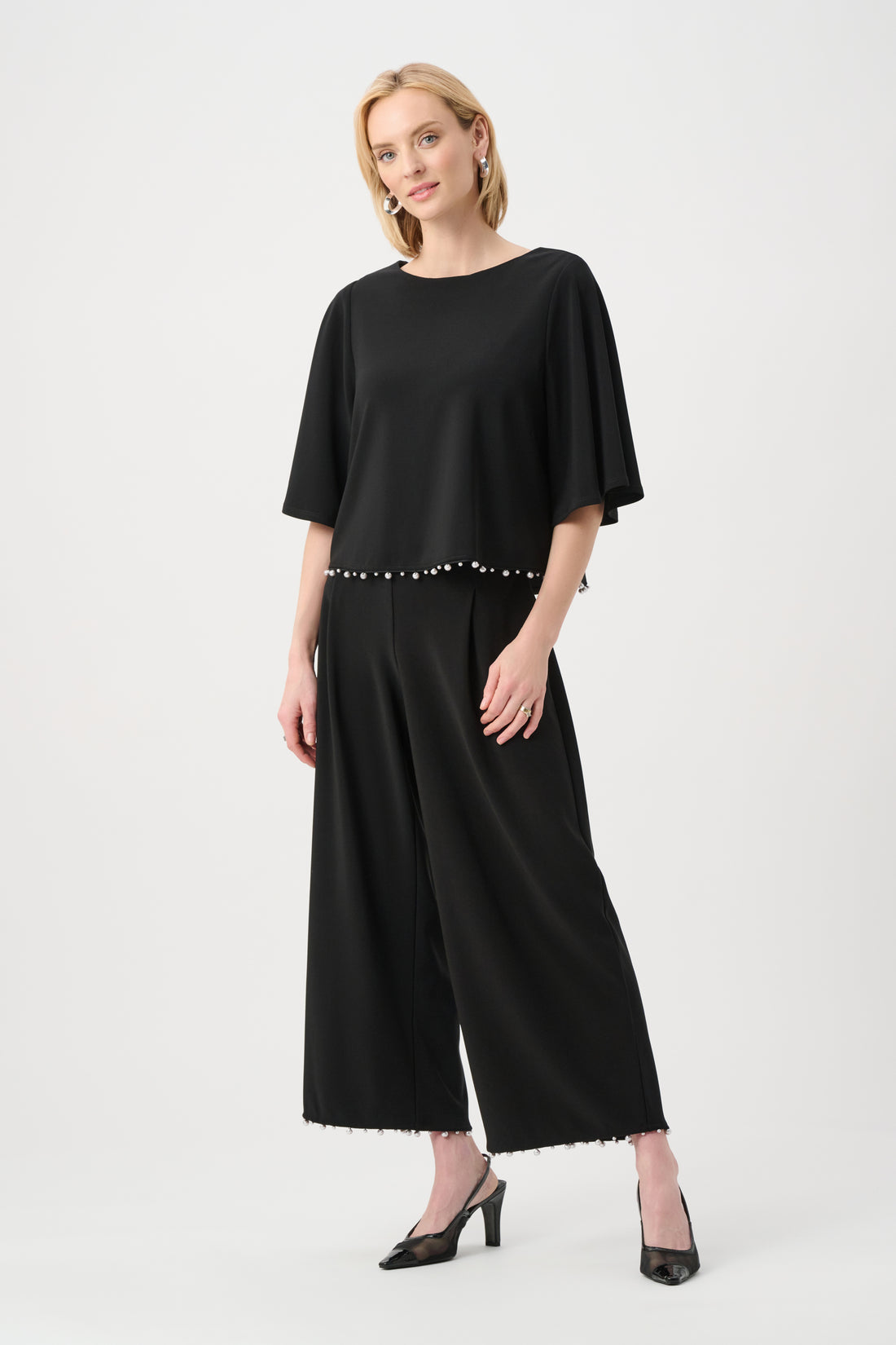 Women’s black silky knit flared top with pearl detail hem and wide sleeve design
