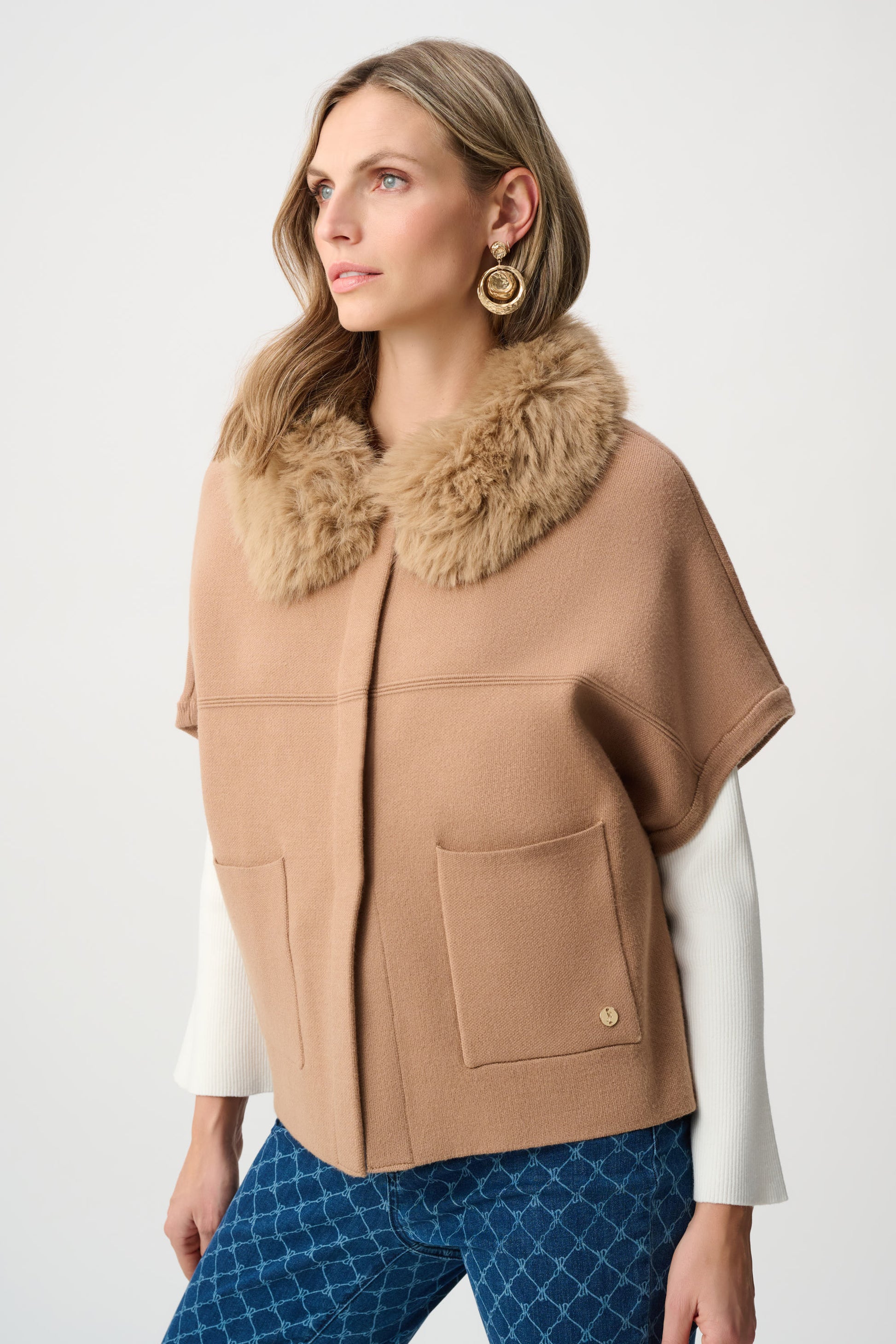 Woman wearing beige cape jacket with faux fur collar side view Adelaide boutique
