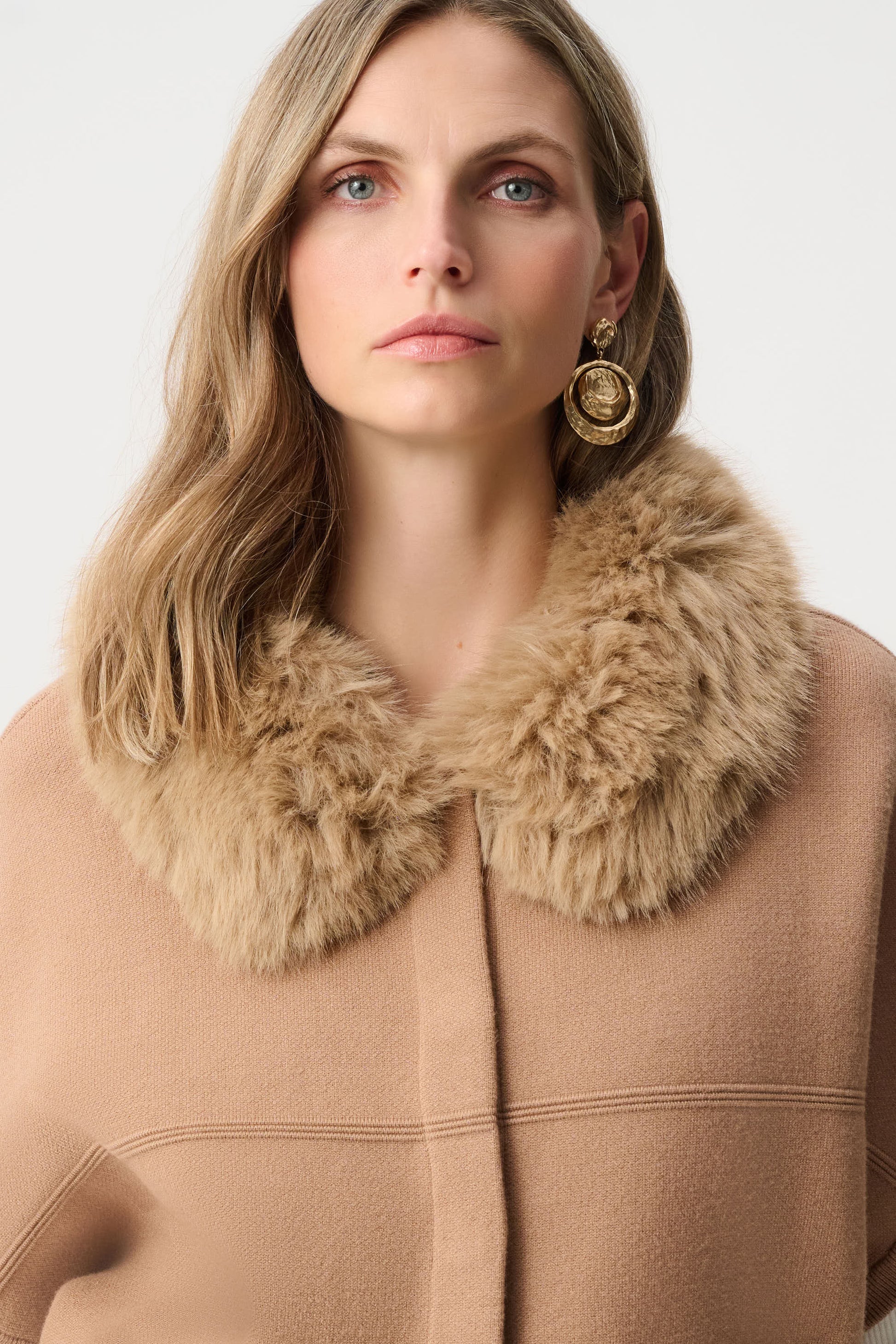 Model showing back of beige cape jacket with pintuck detailing Australia