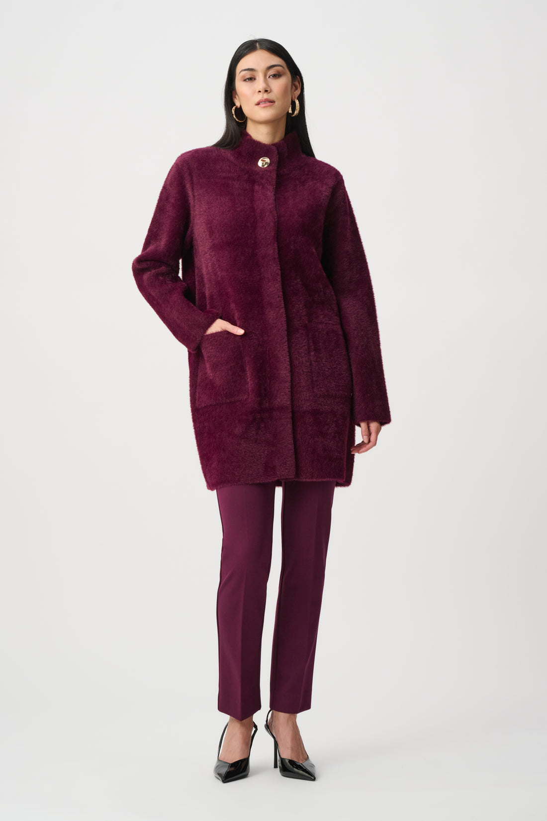 Woman wearing burgundy textured mock neck coat full length studio