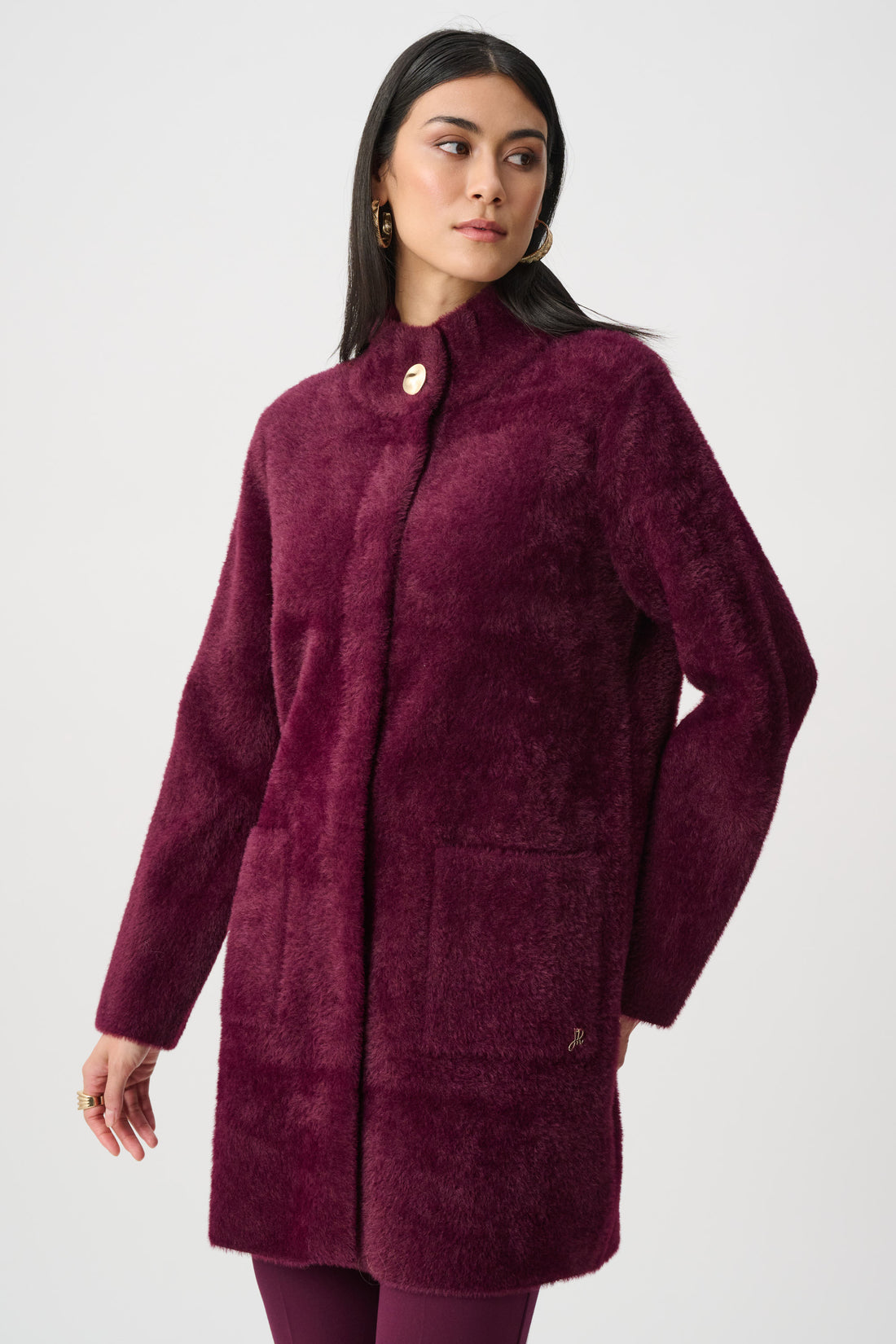 Woman wearing burgundy textured mock neck coat full length studio