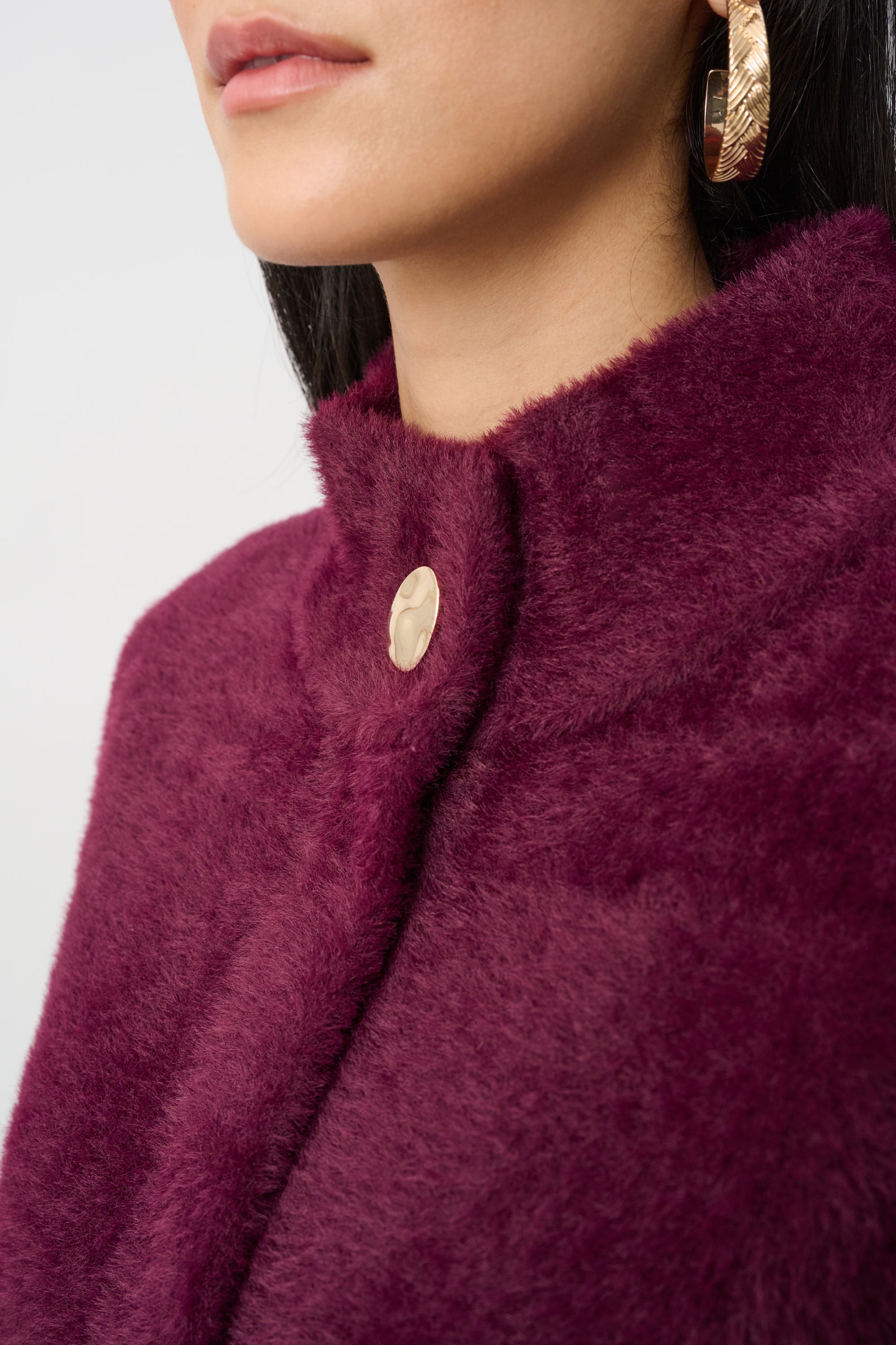 Close up burgundy mock neck coat texture and button detail