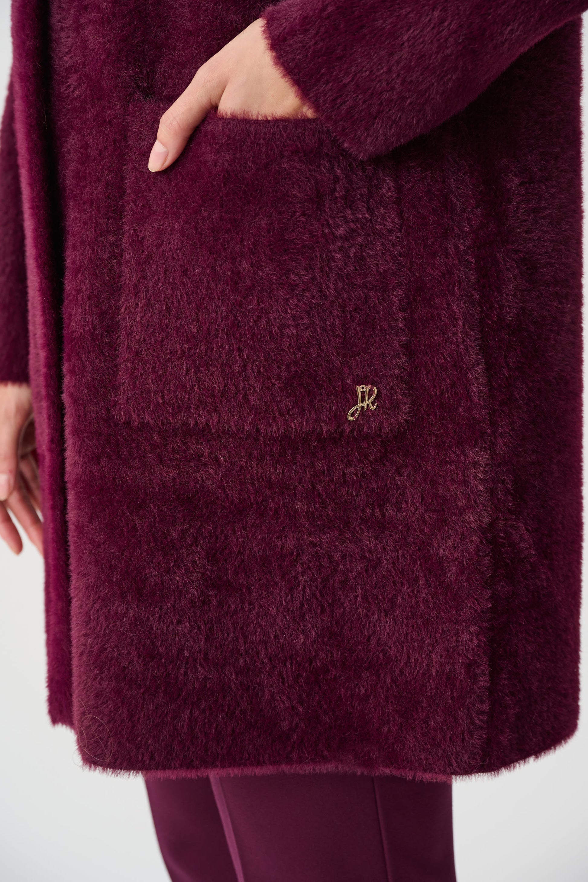 Burgundy textured coat pocket detail soft plush fabric close up