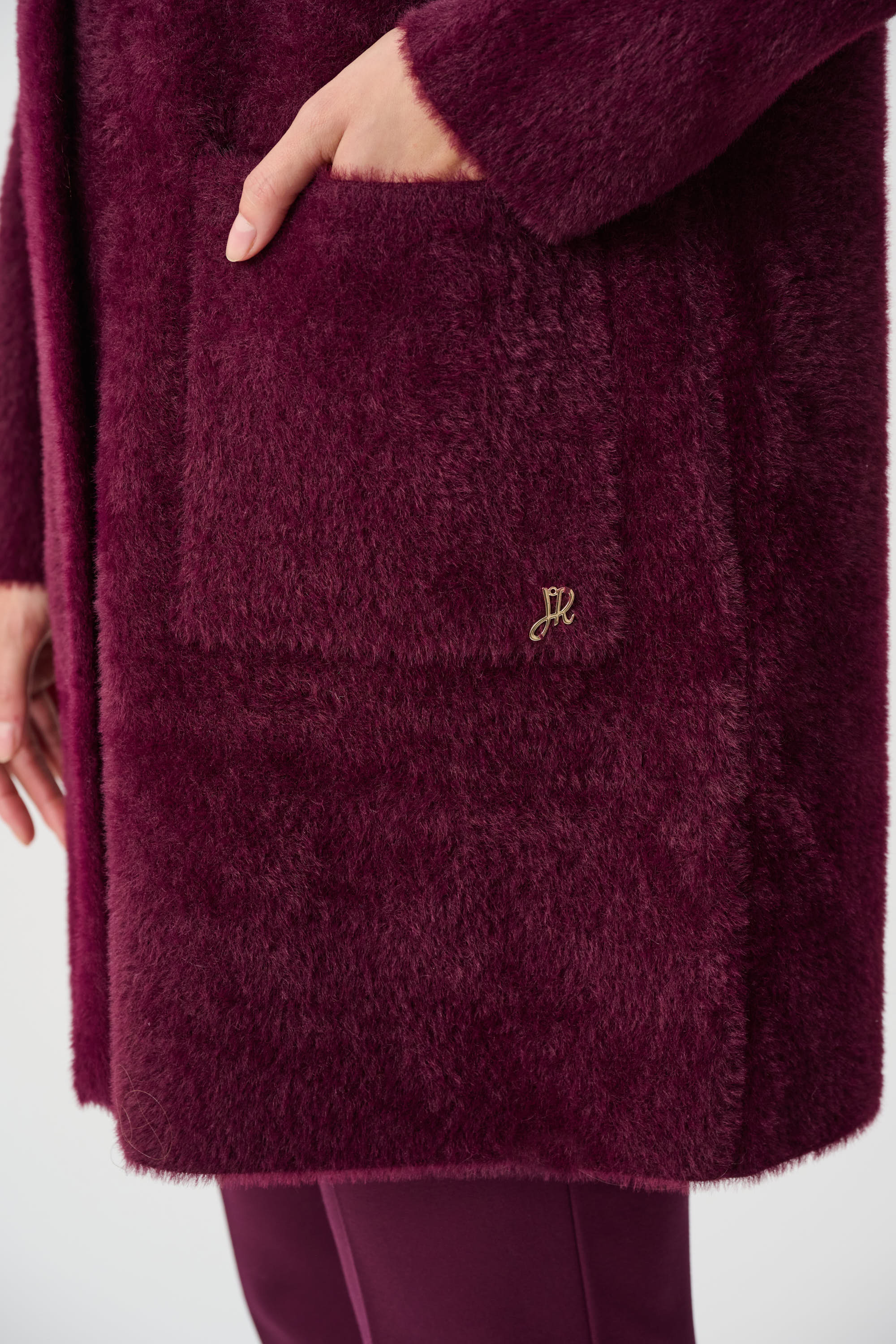 Burgundy textured coat pocket detail soft plush fabric close up