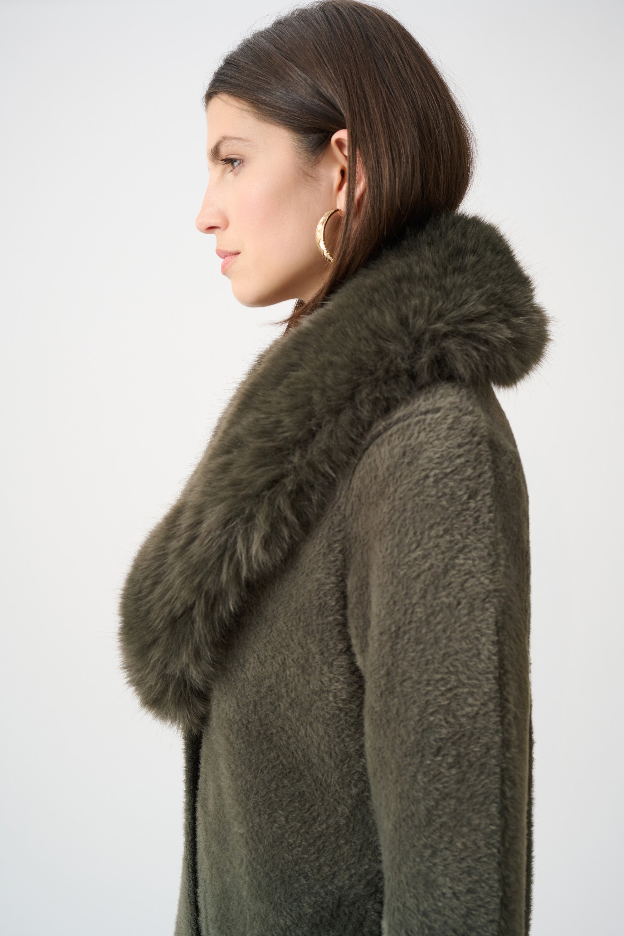 Beige coat with faux fur collar flat lay on white background