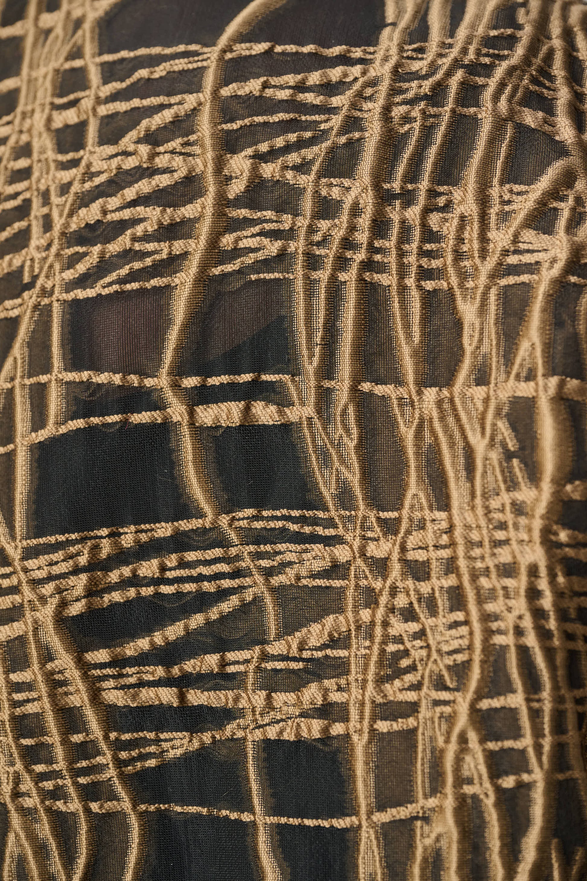 Black and tan abstract patterned jacket fabric close-up