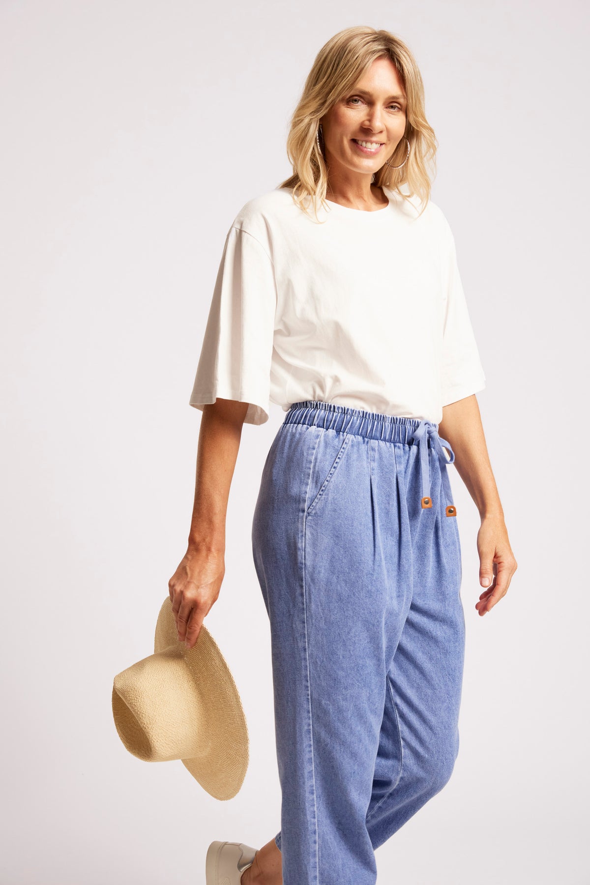 Light blue denim jogger pants styled with a white top for casual wear.