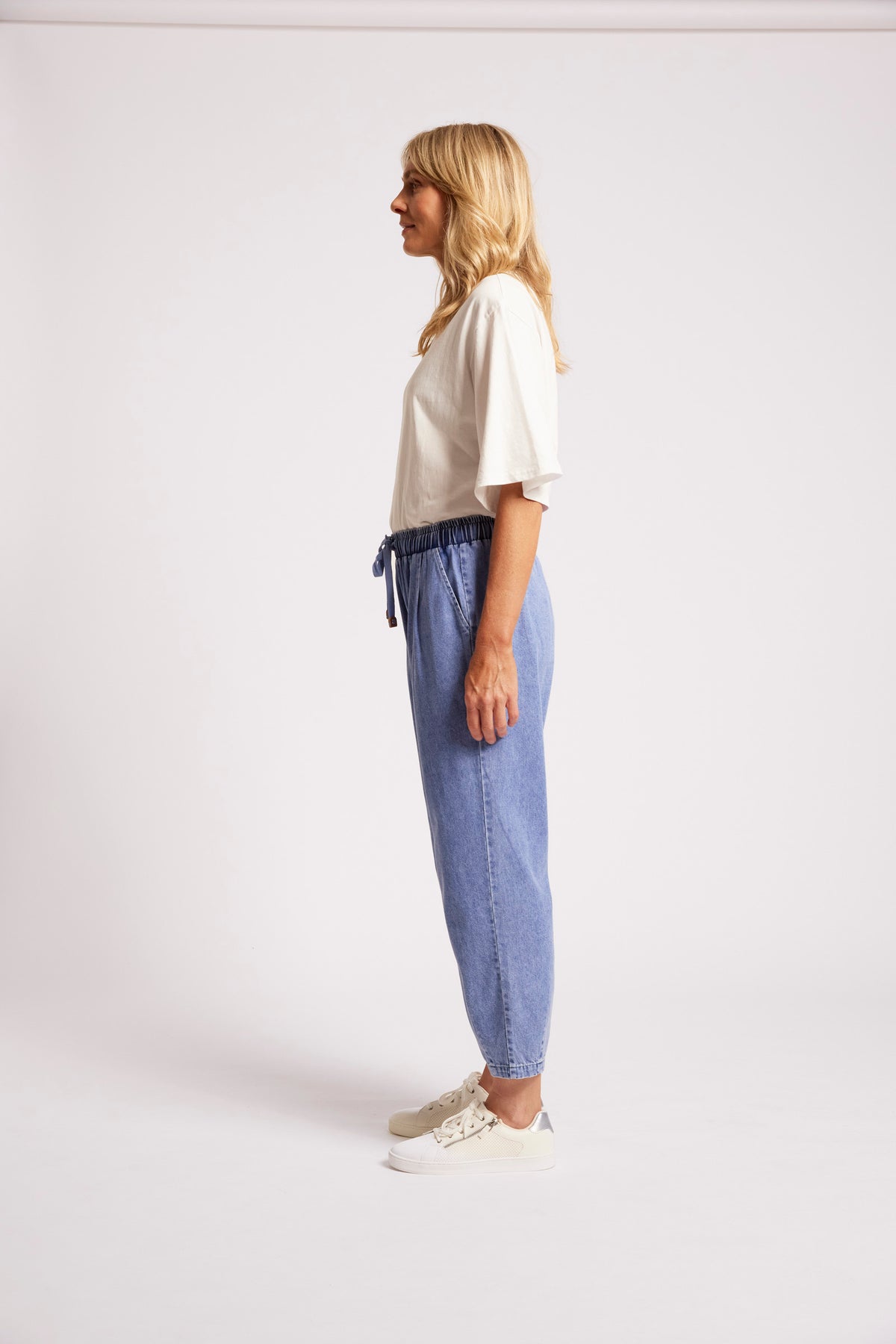 Light blue denim jogger pants with drawstring waist and tapered fit.