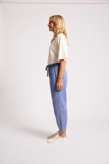 Light blue denim jogger pants with drawstring waist and tapered fit.