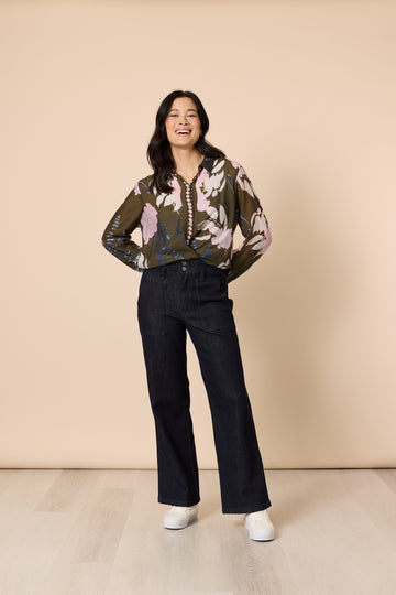 Woman in khaki floral blouse and dark denim wide leg jeans front pose
