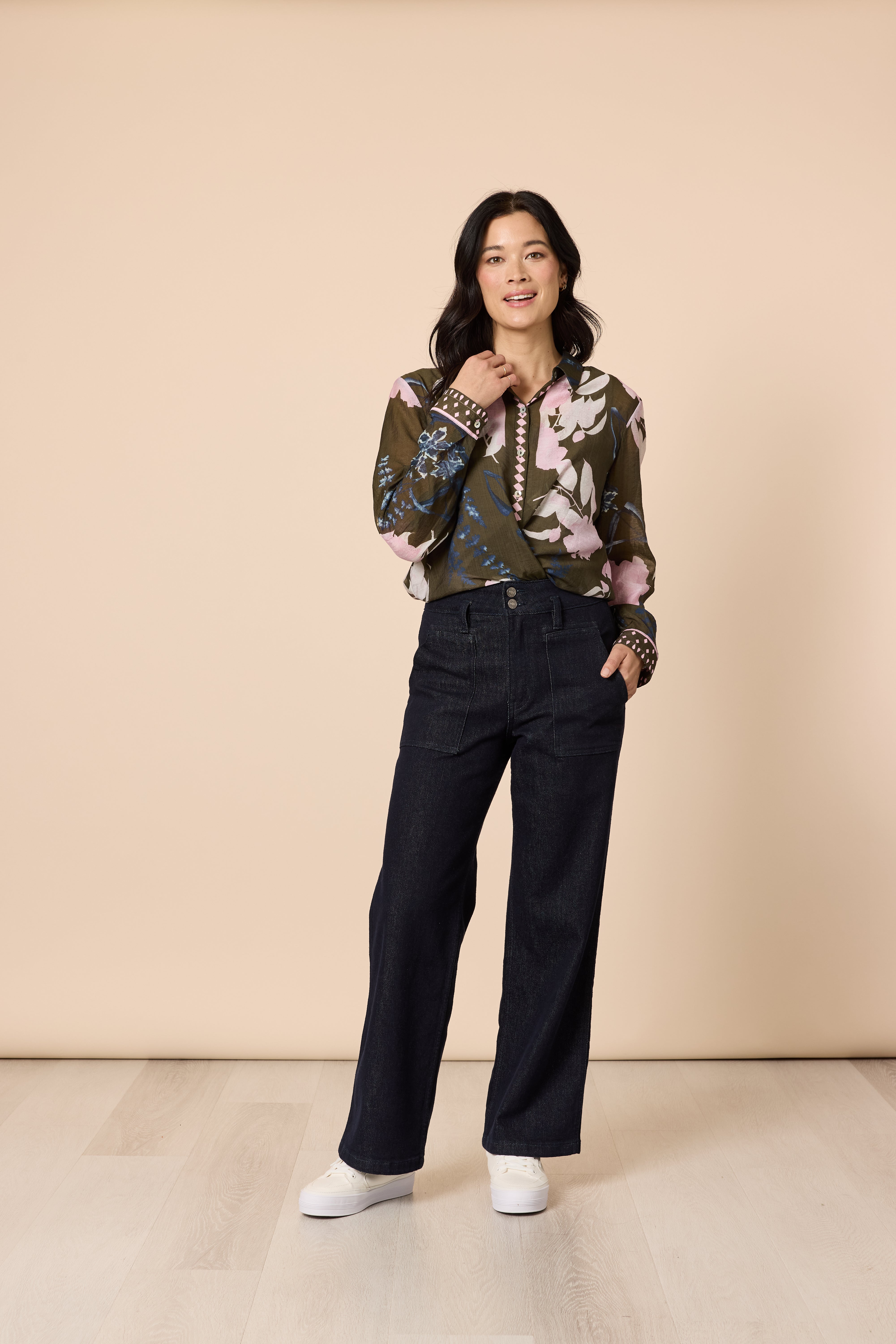 Front view woman in khaki multi print blouse paired with dark denim pants