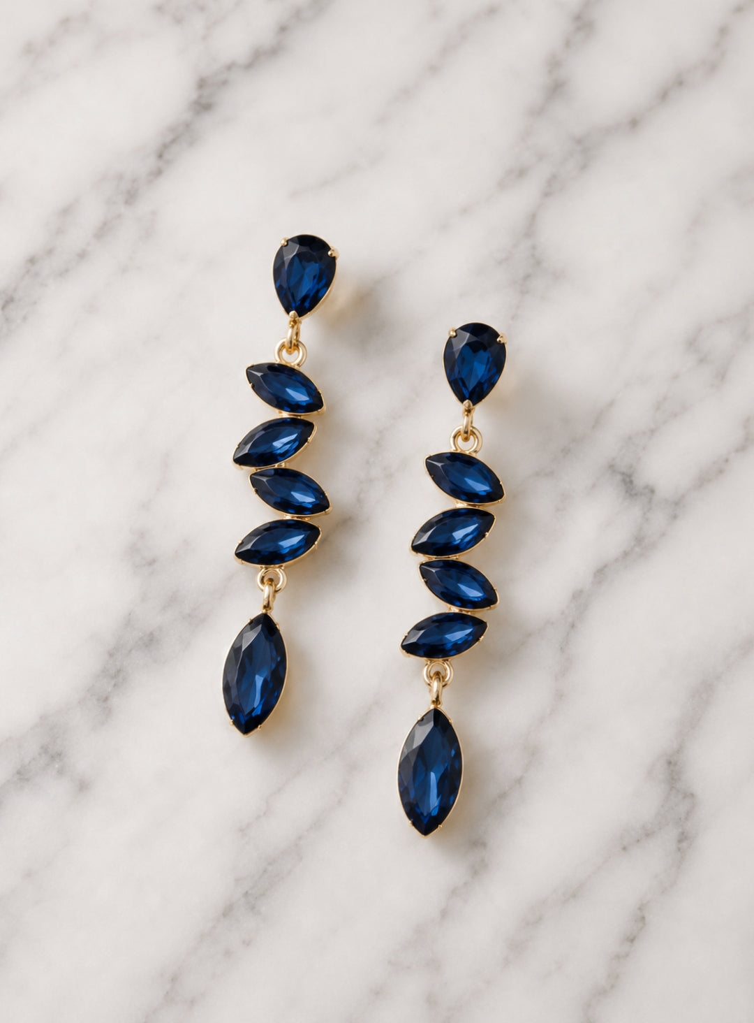 Showies Boutique midnight blue crystal teardrop statement earrings on marble background