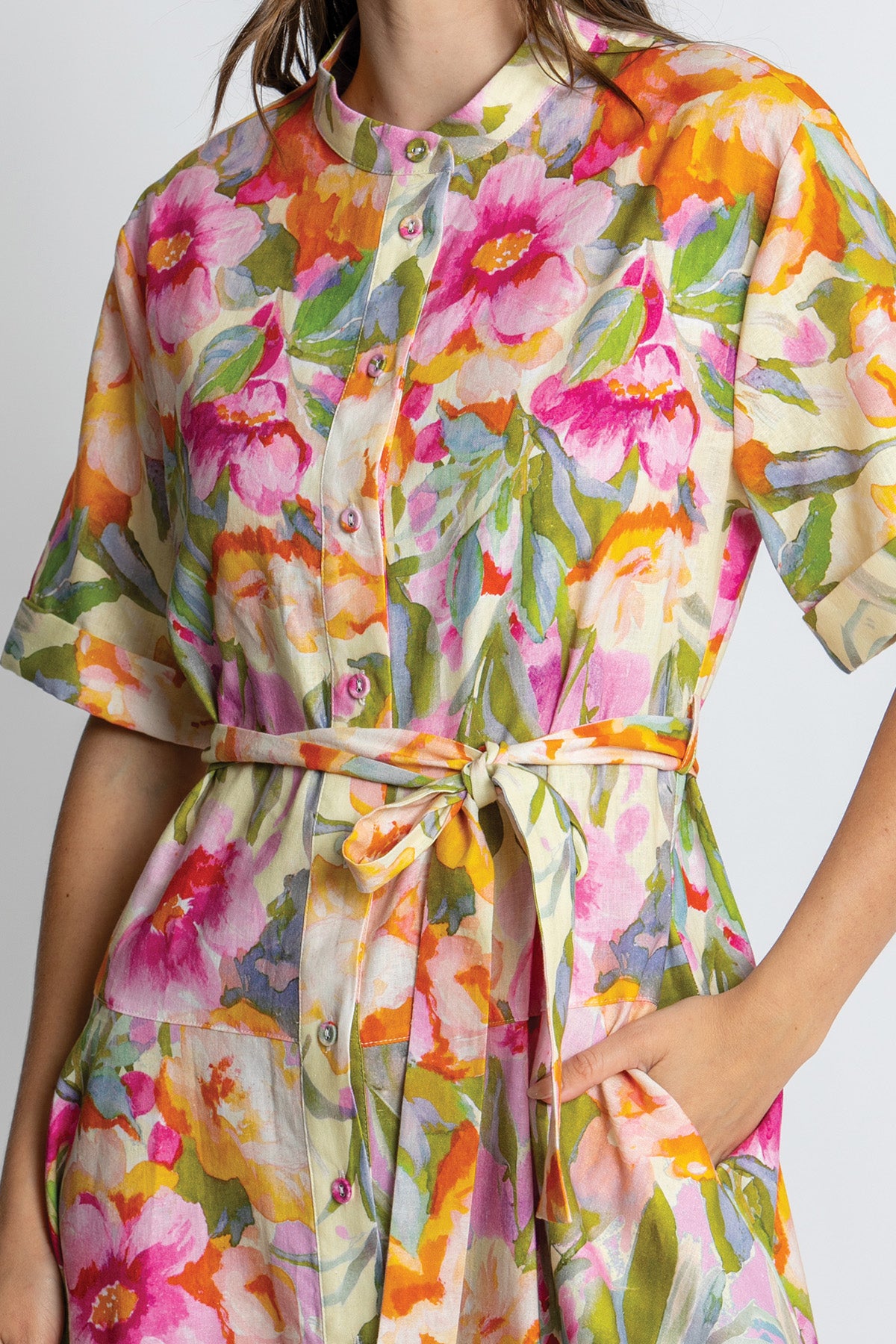 Close-up of button-front floral dress with waist tie.