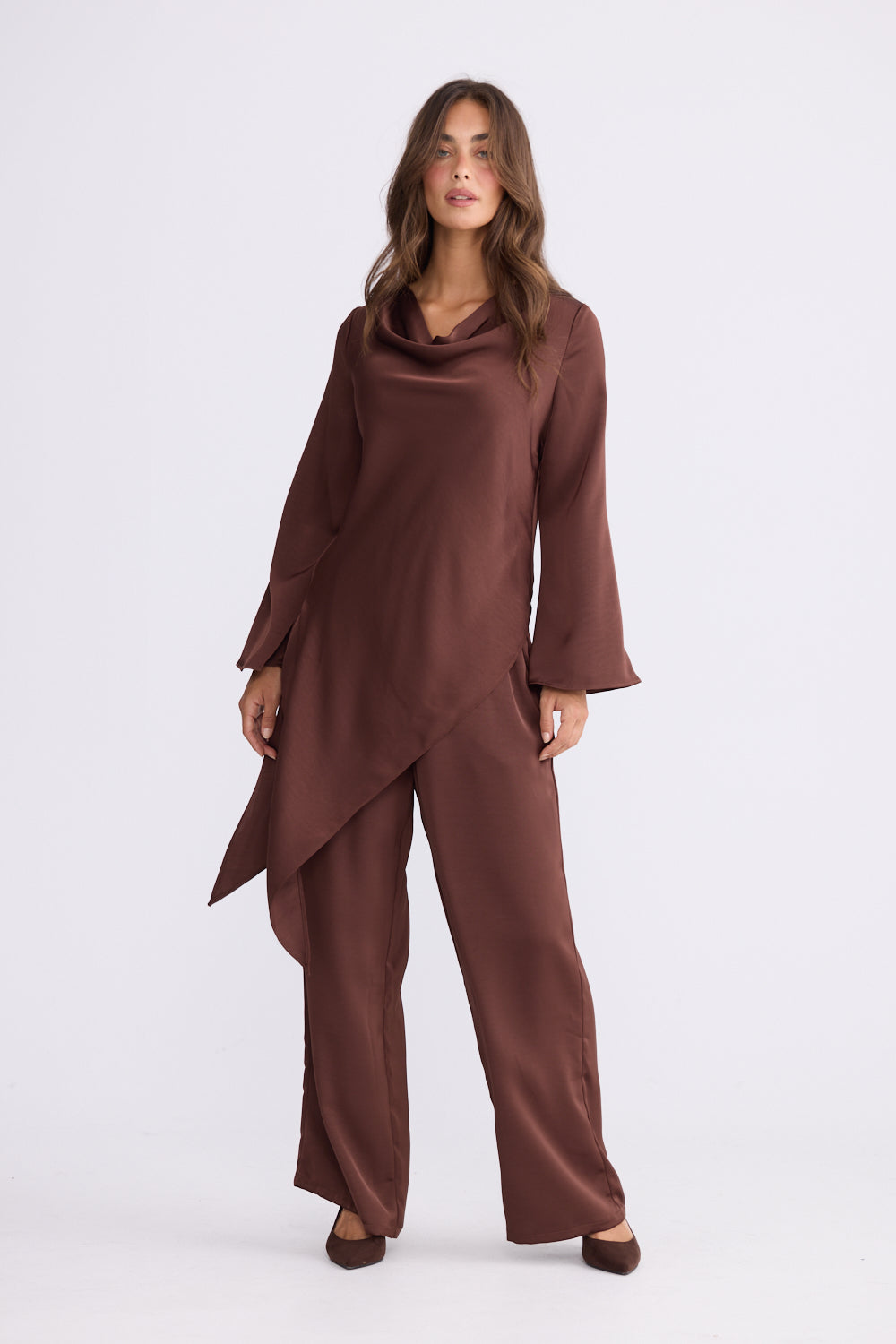 Chocolate brown draped top styled for elevated casual look with fluid asymmetric hem