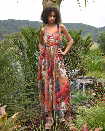 Multicolour floral maxi dress with ruched waist in tropical garden setting.