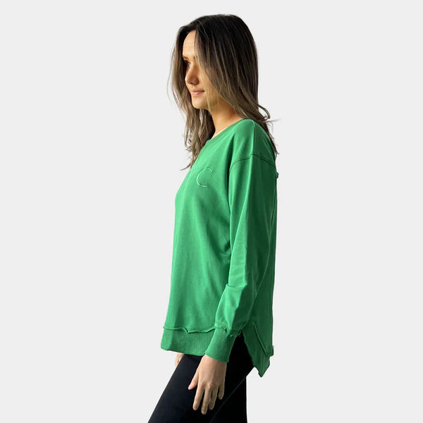 Woman wearing a green sweatshirt on a white background