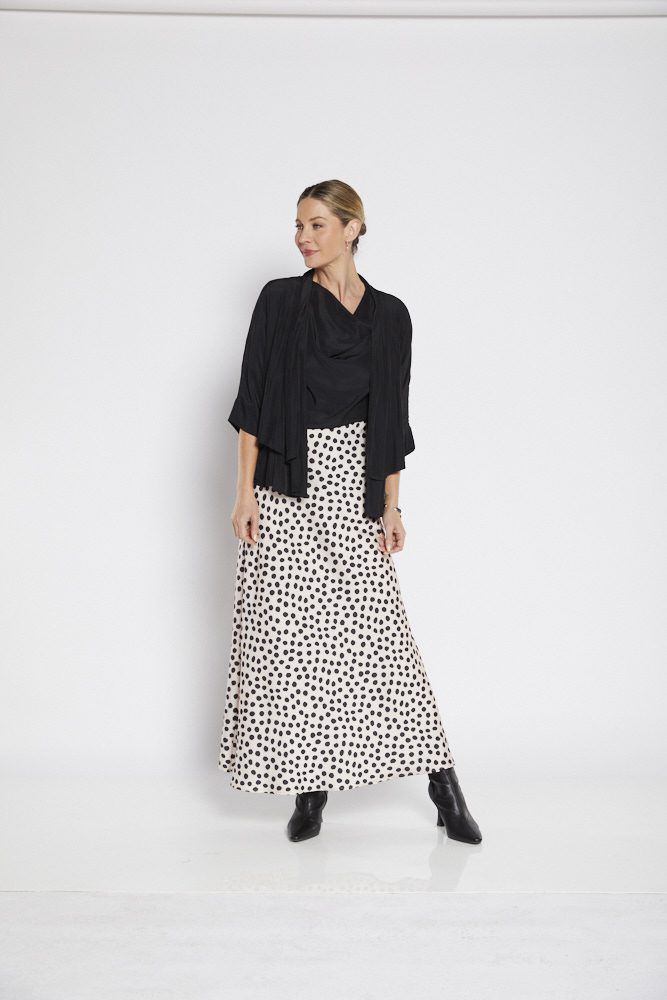 A chic satin maxi skirt with a beige background, adorned with bold black spots for a trendy, contemporary look. Perfect for dressy or casual occasions.