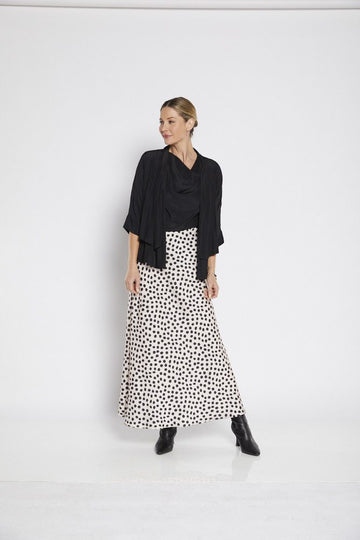A chic satin maxi skirt with a beige background, adorned with bold black spots for a trendy, contemporary look. Perfect for dressy or casual occasions.