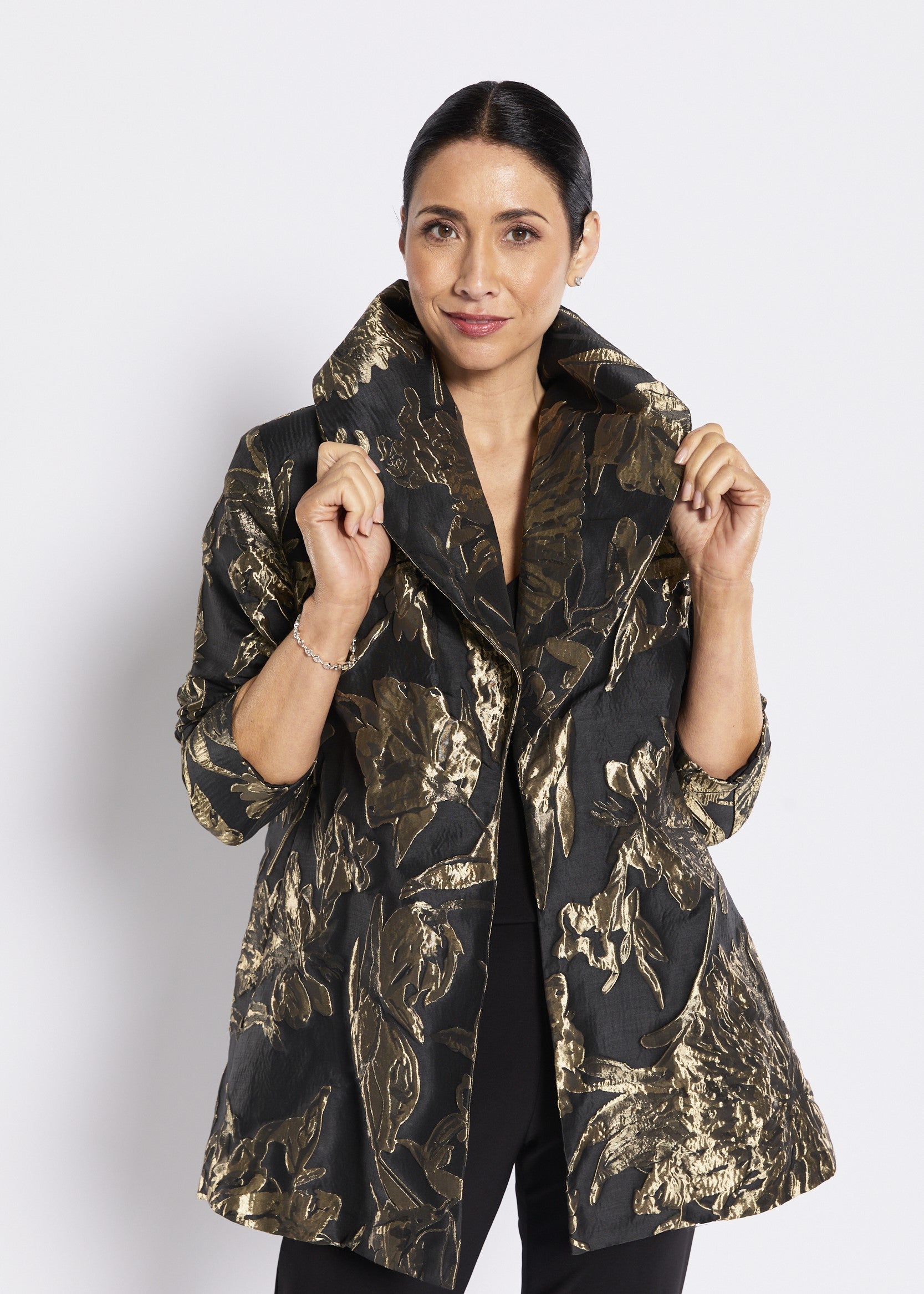 Black and gold floral patterned coat on white background.