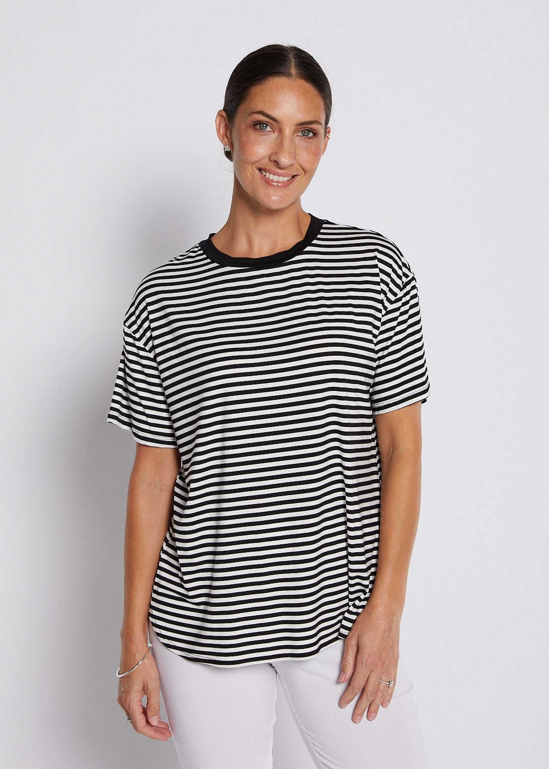 Black and white striped relaxed top with short sleeves, round neckline, and curved hem styled for casual everyday wear.