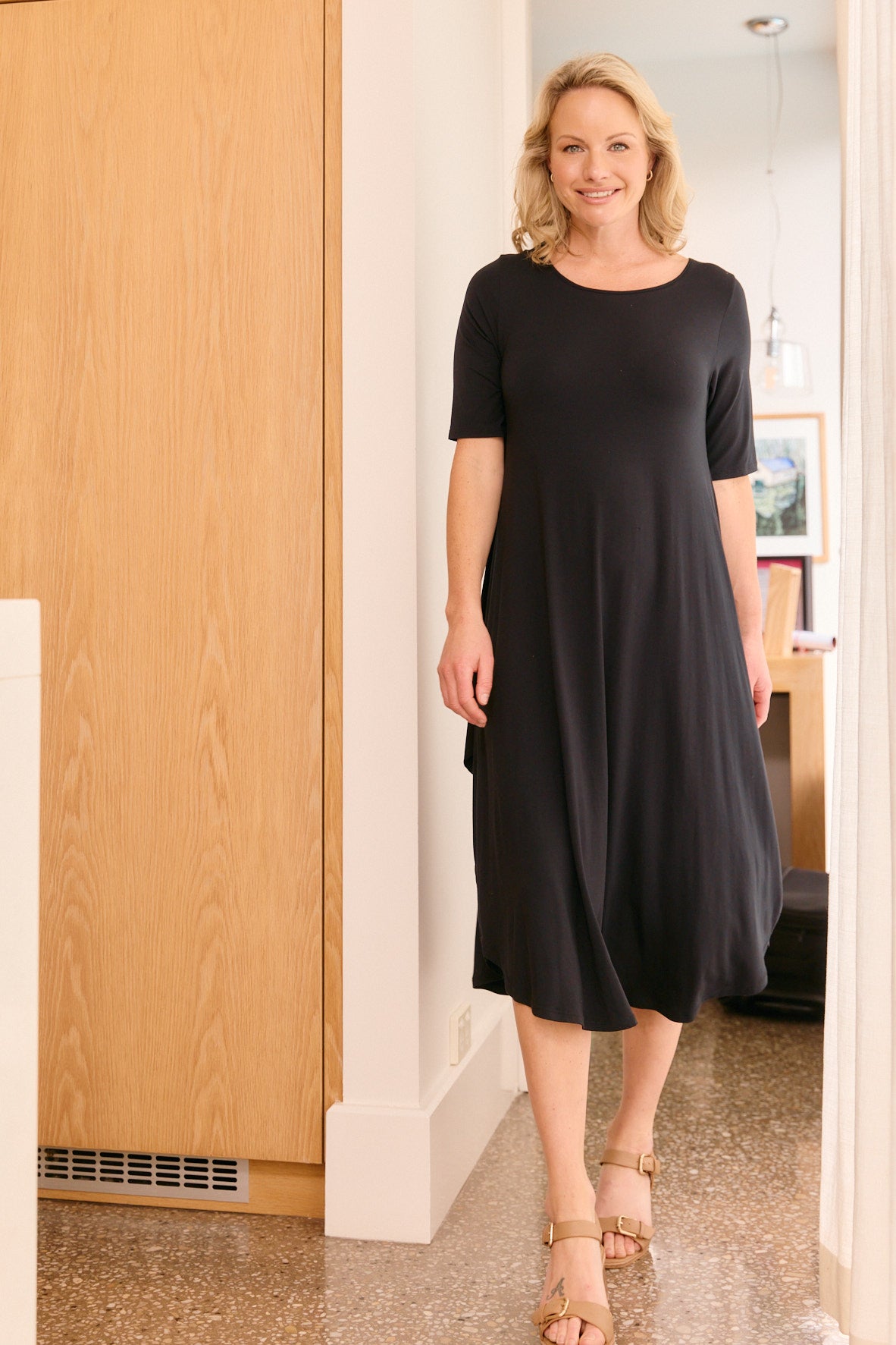 Woman wearing black midi dress indoors minimal home fashion look