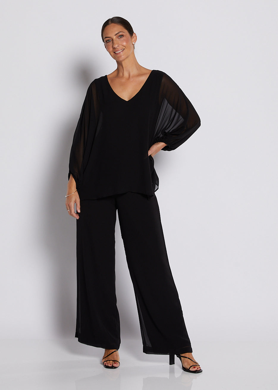 Black chiffon V-neck top with sheer batwing sleeves and wide-leg pants.