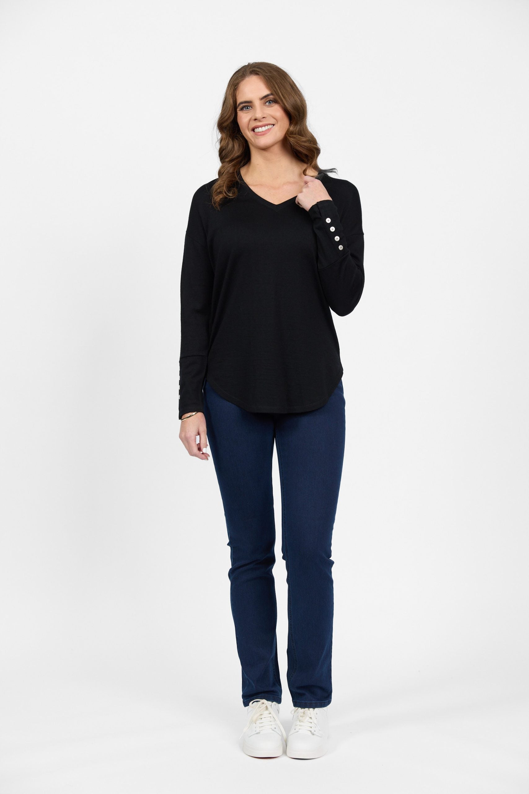 Black merino long sleeve top with button cuff and blue jeans