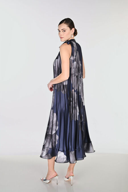 Navy blue and grey pleated midi dress featuring a floral print, high neckline with tie detail, and flowing A-line silhouette for elegant occasion wear.