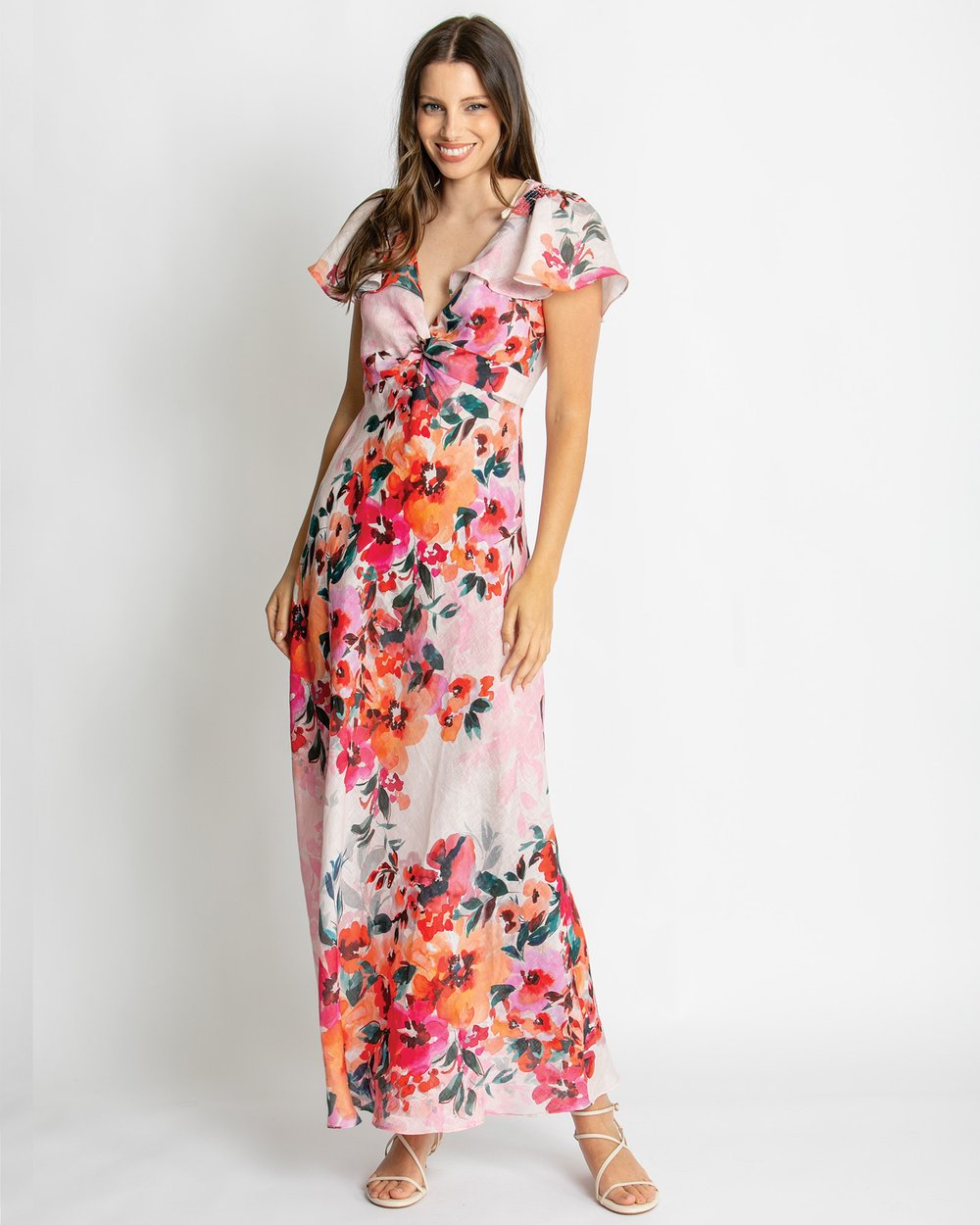 Pink floral maxi dress featuring a vibrant botanical print, flattering sweetheart neckline, flutter sleeves, and flowing silhouette for elegant summer occasion wear.