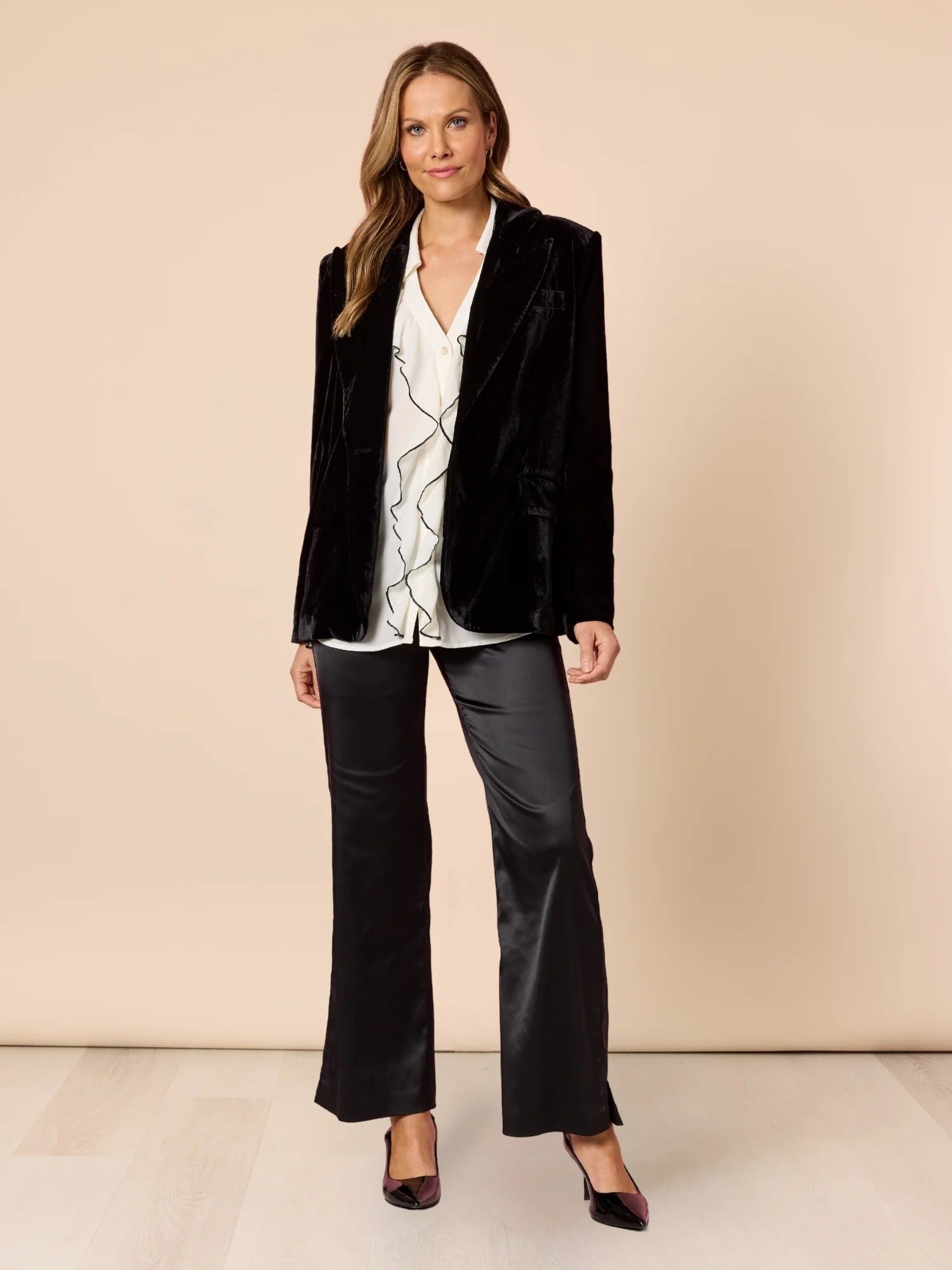 Woman wearing black velvet tailored blazer styled with white blouse and satin black pants, elegant full outfit look from Showies Boutique Adelaide