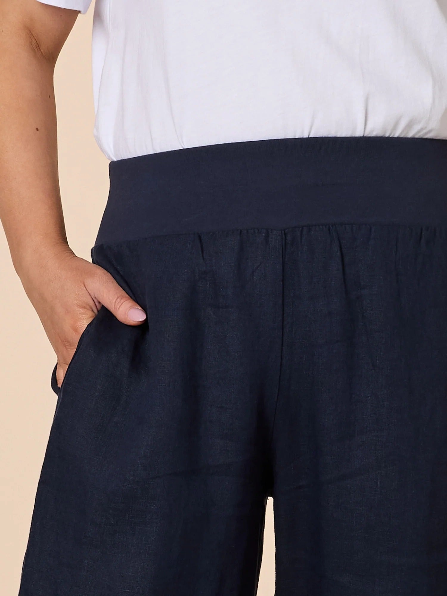 Close-up of navy wide leg denim pants showing elastic waistband and pocket detail, styled with white top, from Showies Boutique Adelaide