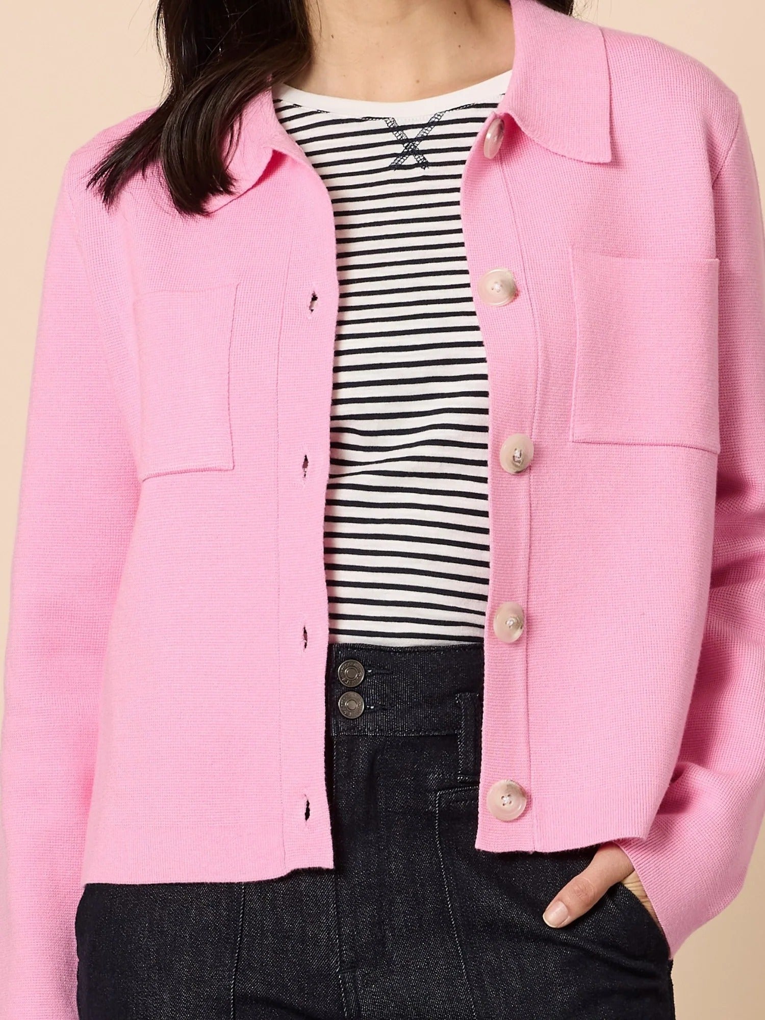Close-up of pink knit collar cardigan with textured fabric, button front and patch pockets, layered over striped top with dark denim, from Showies Boutique Adelaide