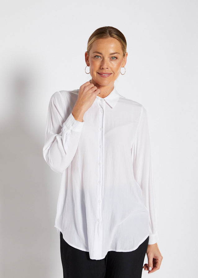 Woman in a white blouse against a plain background